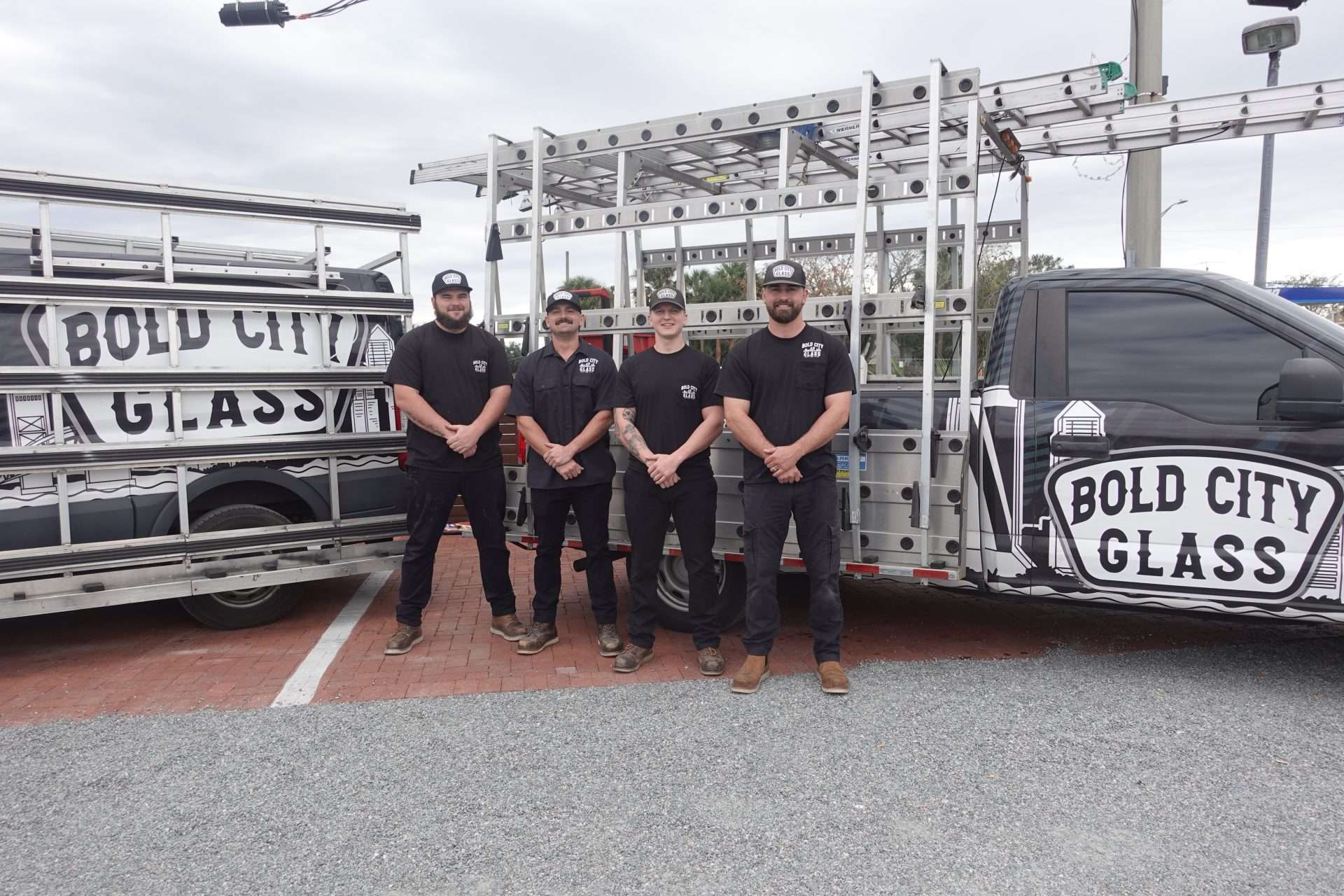Four men in front of Bold City Glass vans.
